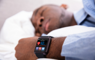 A sleeping man wearing a Fitbit