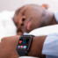 A sleeping man wearing a Fitbit